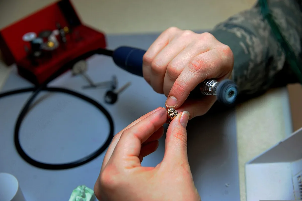 U.S. Air Force Senior Airman Meghan Mayhew, a dental lab technician with the 628th Medical Group, polishes a gold crown at the Joint Base Charleston dental lab in South Carolina Sept 110922-F-AV409-006